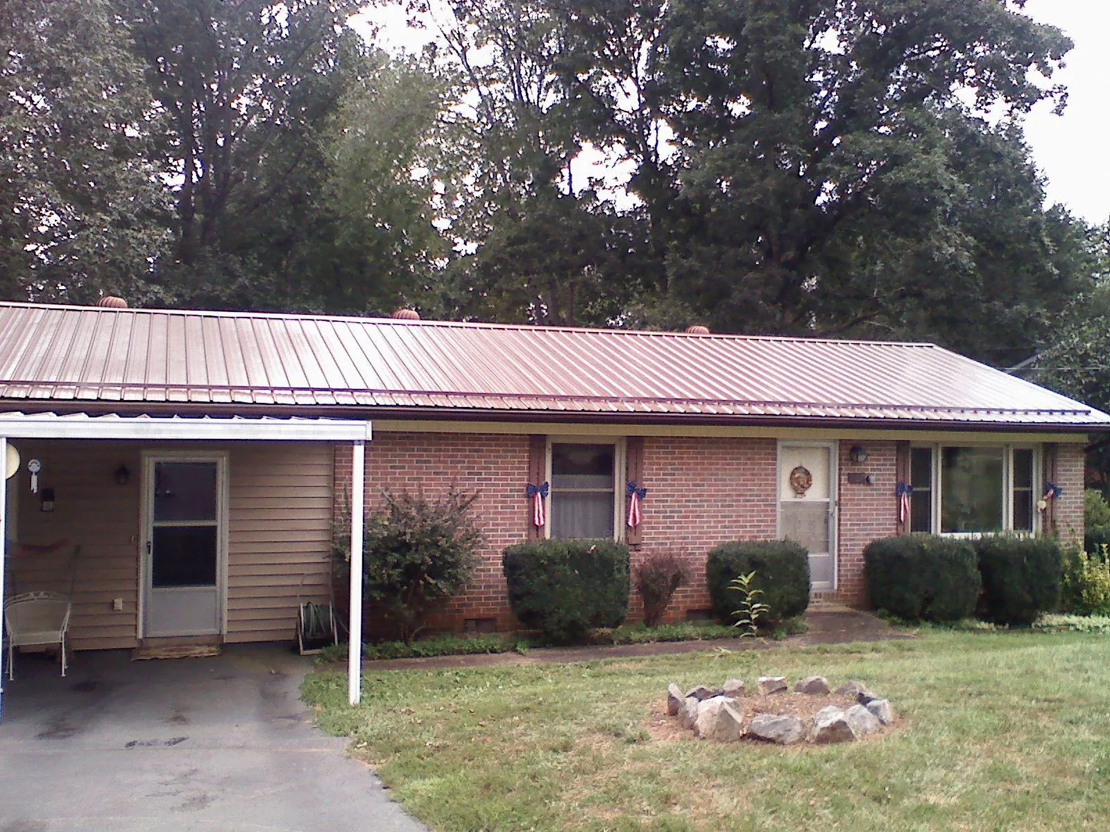 Bronze metal roof and carport on a brick ranch home — Roof Repair work by our crew in Leverett